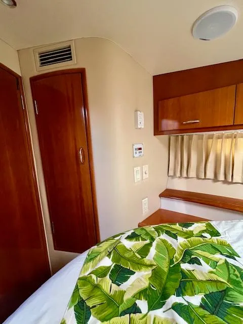 Slide: The Image of Interior of 2003 Carver 360 Sport Sedan with wood paneling and tropical bedding. - 34