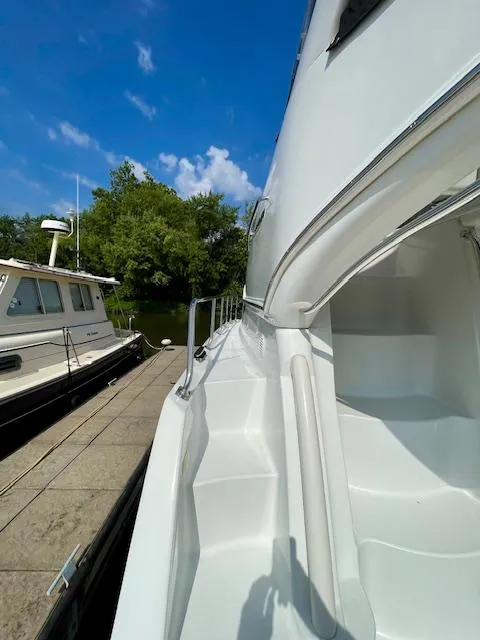 Slide: The Image of 2003 Carver 360 Sport Sedan docked, showcasing sleek white exterior and clear blue sky. - 9