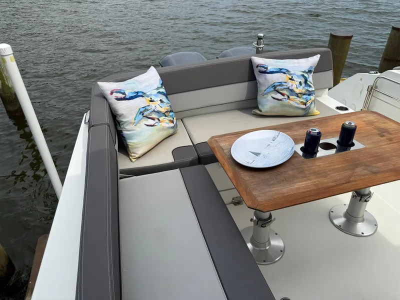 Slide: The Image of Cozy seating area on 2018 Jeanneau Leader 10.5 boat with decorative crab pillows. - 10