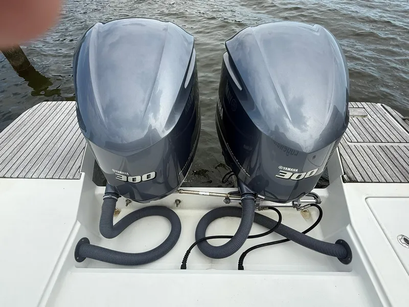 Slide: The Image of Twin Yamaha 300 engines on a 2018 Jeanneau Leader 10.5 boat, docked by the water. - 16