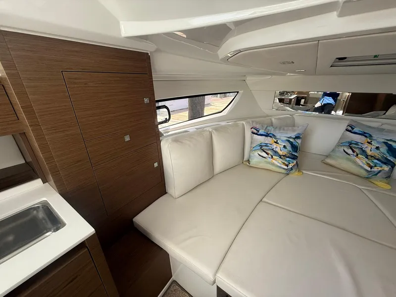 Slide: The Image of Interior of 2018 Jeanneau Leader 10.5 yacht with white seating and colorful pillows. - 19