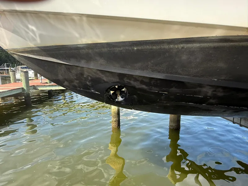 Slide: The Image of 2018 Jeanneau Leader 10.5 boat hull with visible propeller in marina. - 27