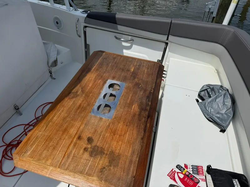 Slide: The Image of 2018 Jeanneau Leader 10.5 boat interior with wooden table and seating area. - 28