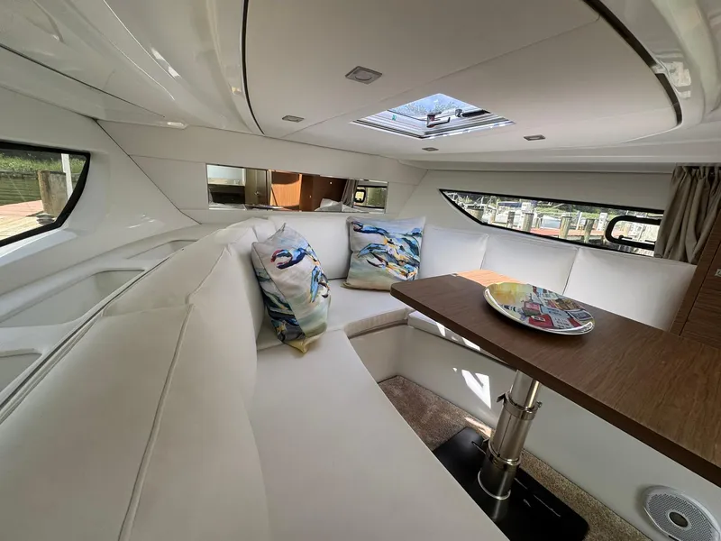 Slide: The Image of Interior of 2018 Jeanneau Leader 10.5 yacht with white seating and wooden table. - 30