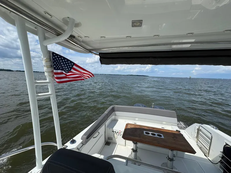 Slide: The Image of 2018 Jeanneau Leader 10.5 boat with American flag on open water. - 33