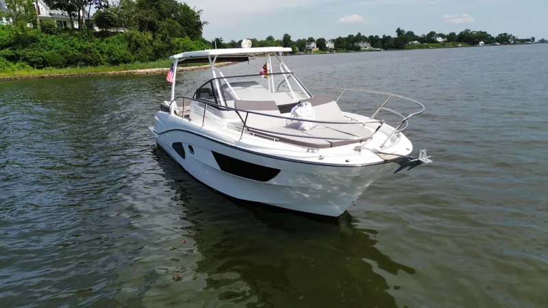 Slide: The Image of 2018 Jeanneau Leader 10.5 boat on calm water near a lush shoreline. - 4