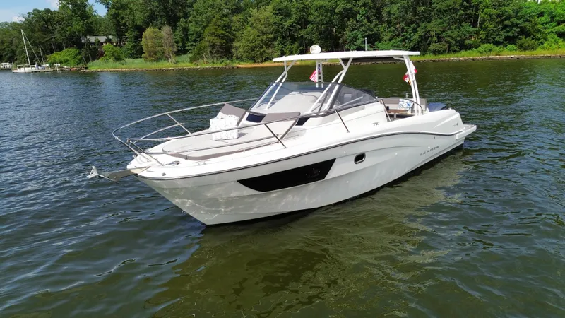Slide: The Image of 2018 Jeanneau Leader 10.5 boat on calm water, surrounded by lush greenery. - 5