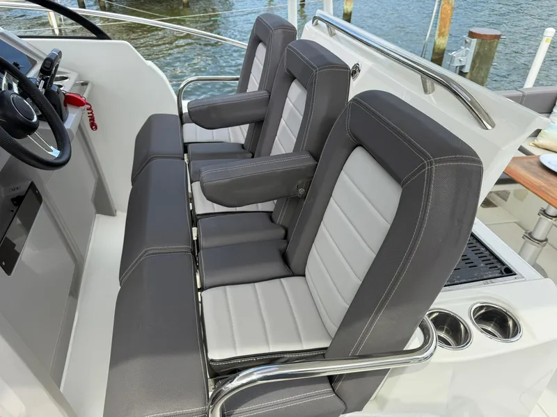 Slide: The Image of 2018 Jeanneau Leader 10.5 boat interior with sleek seating and steering wheel. - 9