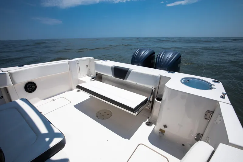 Slide: The Image of 2023 Robalo R270 Center Console boat interior with seating and twin engines on open water. - 10