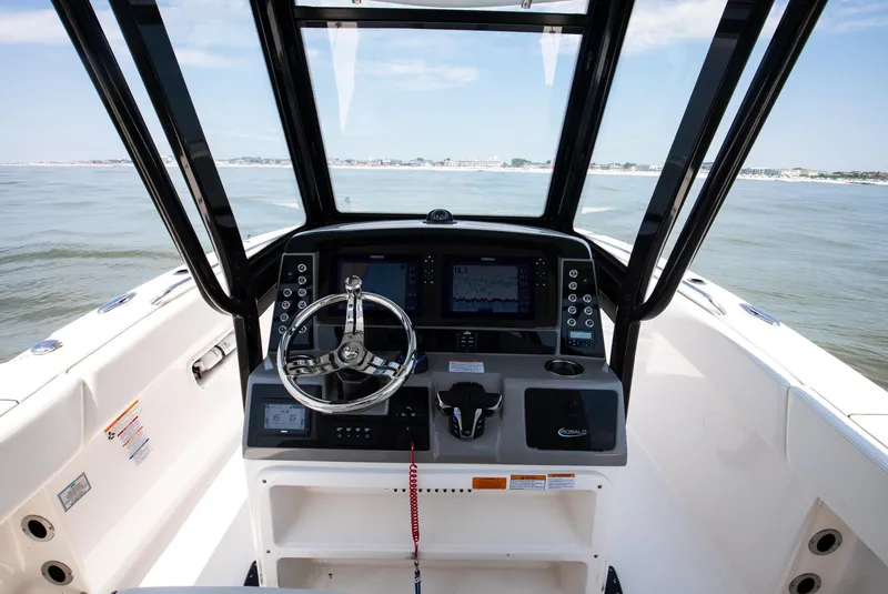 Slide: The Image of 2023 Robalo R270 Center Console boat dashboard with steering wheel and navigation screens. - 3