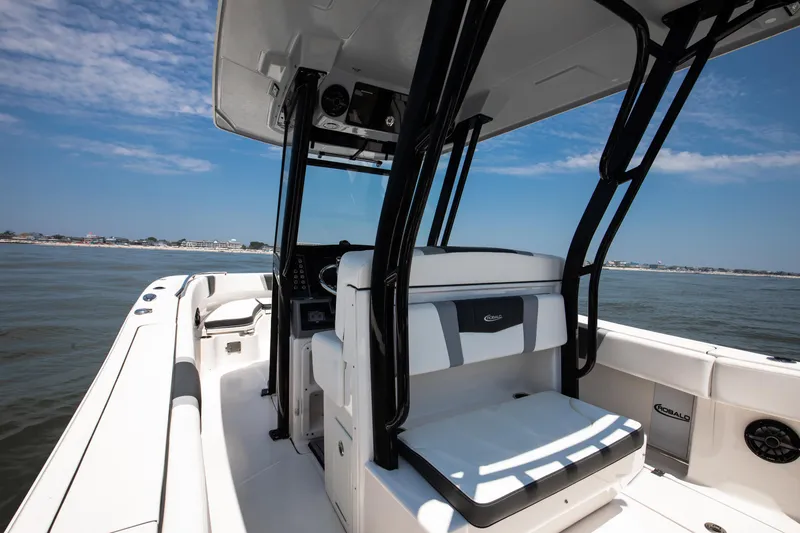 Slide: The Image of 2023 Robalo R270 Center Console boat on calm water, featuring sleek design and spacious seating. - 5
