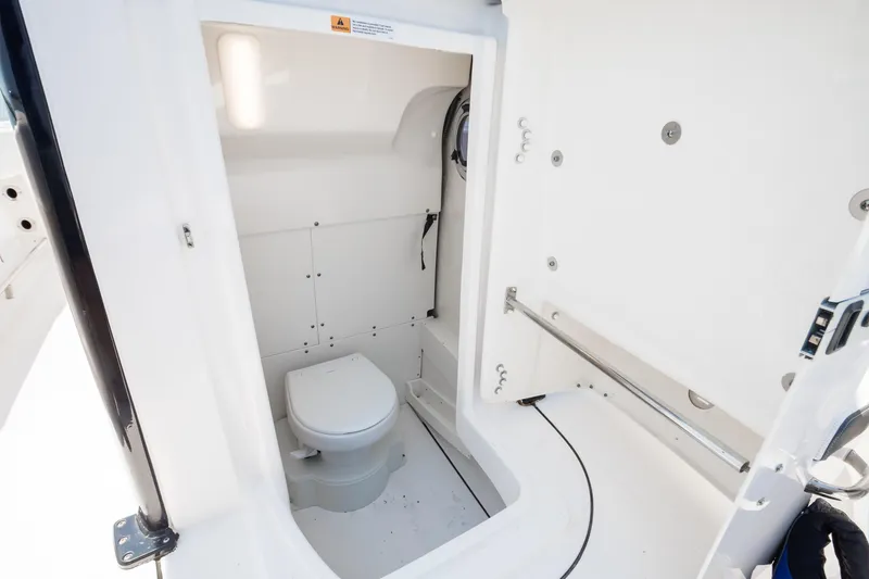 Slide: The Image of 2023 Robalo R270 Center Console boat interior with compact marine toilet. - 9