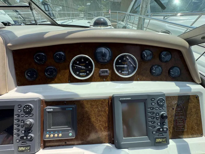 Slide: The Image of Dashboard of a 1995 Sea Ray 400 Express Cruiser with navigation instruments and gauges. - 13