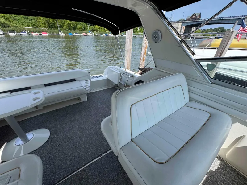 Slide: The Image of 1995 Sea Ray 400 Express Cruiser interior with white seating, table, and river view. - 15
