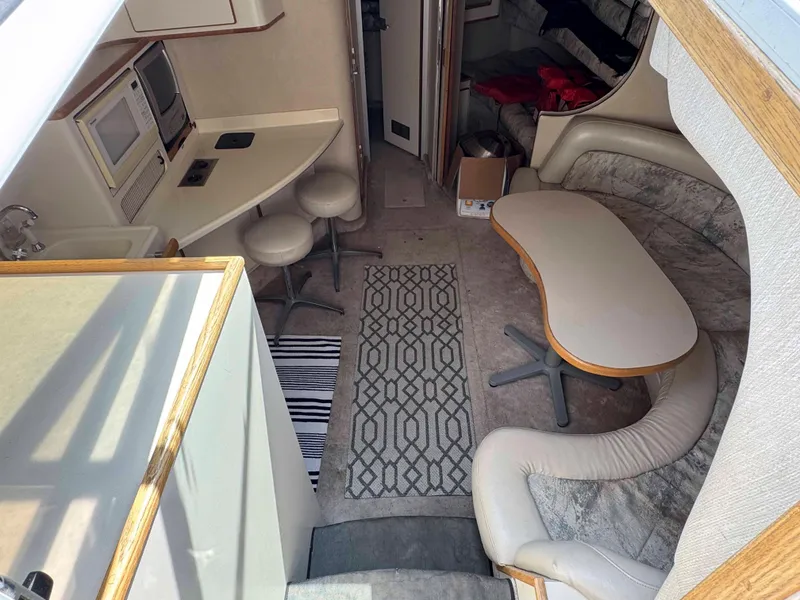 Slide: The Image of Interior of 1995 Sea Ray 400 Express Cruiser with seating, table, and kitchenette. - 17