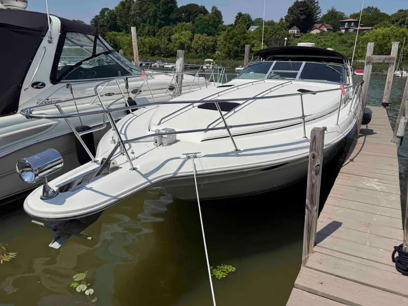 Slide: The Image of 1995 Sea Ray 400 Express Cruiser docked at a marina, surrounded by lush greenery. - 2