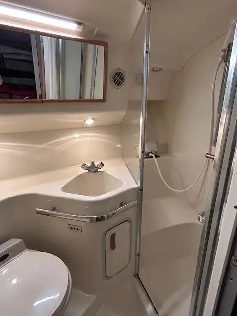 Slide: The Image of 1995 Sea Ray 400 Express Cruiser bathroom with sink, toilet, and shower. - 28