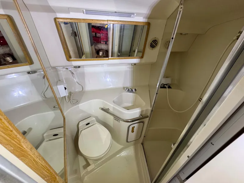 Slide: The Image of Bathroom of 1995 Sea Ray 400 Express Cruiser with shower, toilet, and sink. - 29