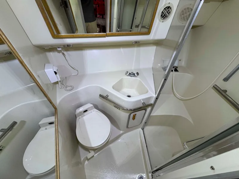 Slide: The Image of Bathroom of 1995 Sea Ray 400 Express Cruiser with toilet, sink, and shower. - 31