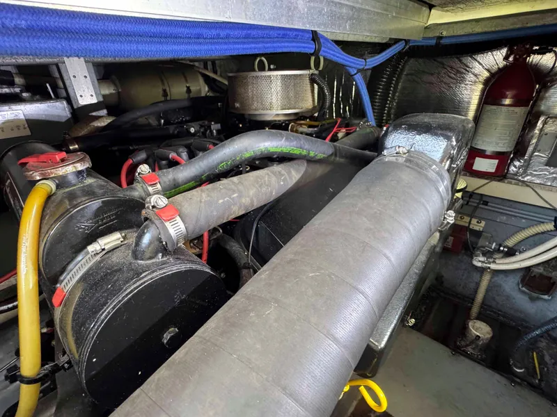 Slide: The Image of Engine compartment of a 1995 Sea Ray 400 Express Cruiser with visible hoses and components. - 35