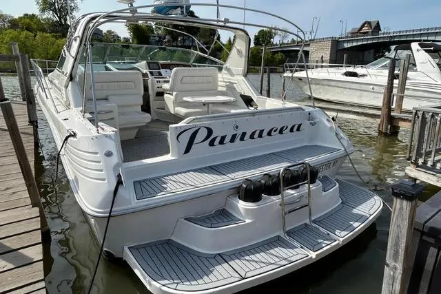 Slide: The Image of 1995 Sea Ray 400 Express Cruiser docked, named "Panacea," with spacious seating and sleek design. - 4