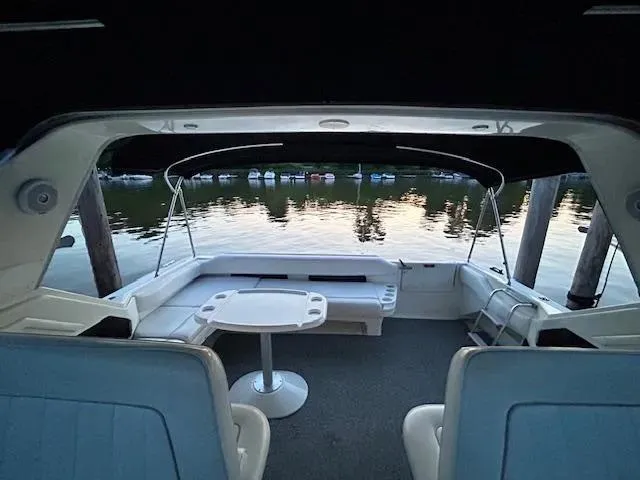 Slide: The Image of 1995 Sea Ray 400 Express Cruiser interior with lake view, featuring seating and table. - 7