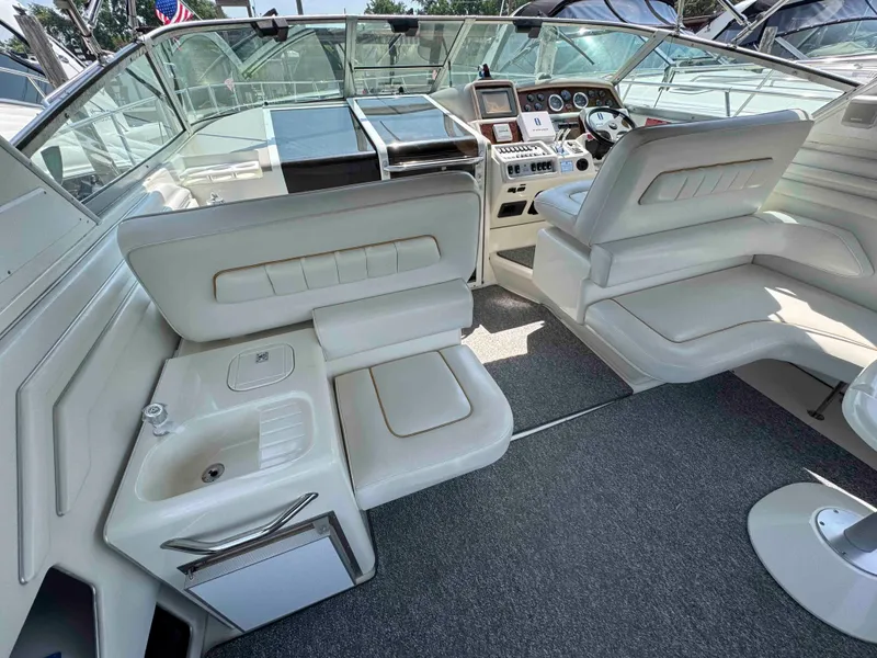 Slide: The Image of 1995 Sea Ray 400 Express Cruiser interior with white seating and helm station. - 8