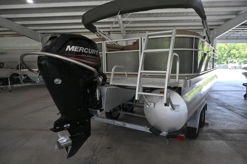 Slide: The Image of 2019 Bennington 22 SSR pontoon boat with Mercury outboard motor in a covered storage area. - 5