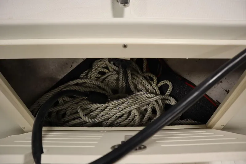 Slide: The Image of Storage compartment with coiled rope in a 2017 Mako 284 CC boat. - 16