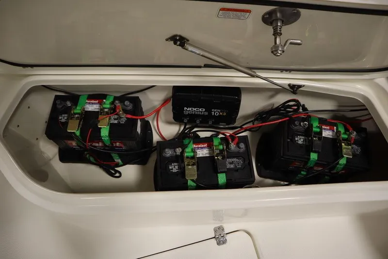 Slide: The Image of Battery compartment of 2017 Mako 284 CC boat with multiple batteries and wiring. - 17