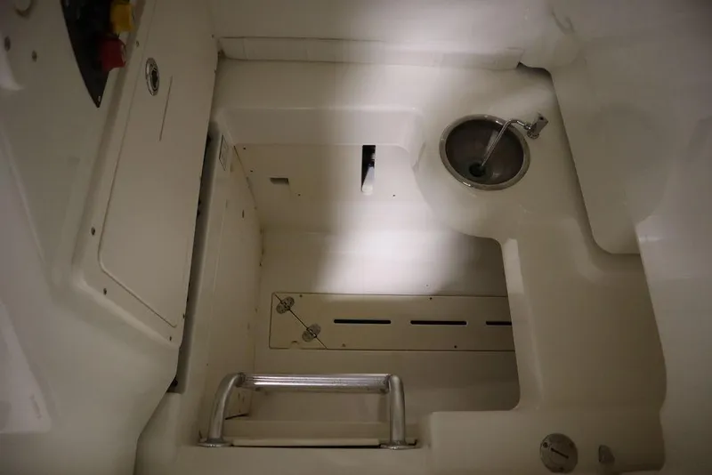 Slide: The Image of Interior view of a 2017 Mako 284 CC boat, featuring a sink and storage compartments. - 23