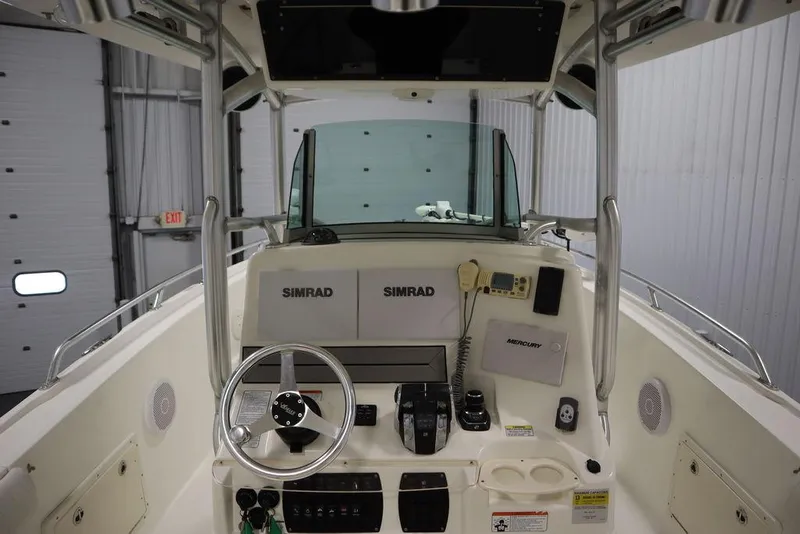 Slide: The Image of 2017 Mako 284 CC boat console with Simrad electronics in a garage setting. - 31