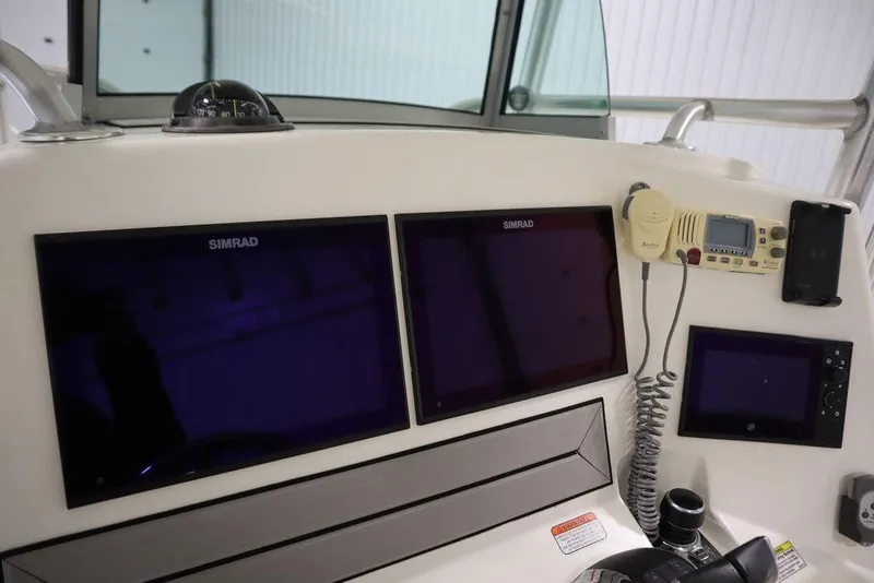 Slide: The Image of Control panel of 2017 Mako 284 CC boat with Simrad displays and communication equipment. - 32