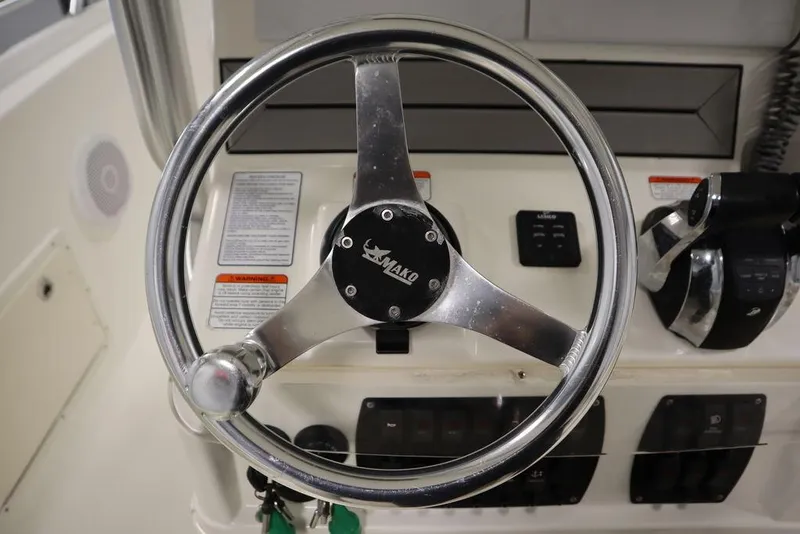 Slide: The Image of Steering wheel of a 2017 Mako 284 CC boat, featuring control panel and throttle. - 33