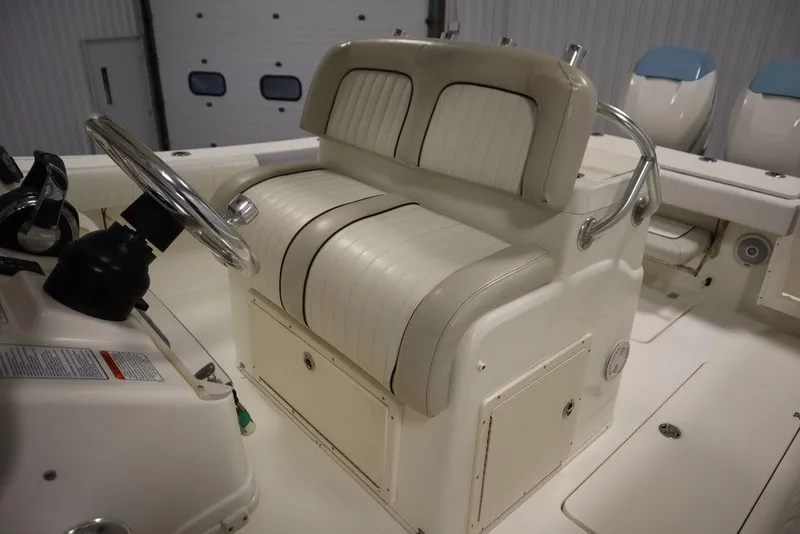 Slide: The Image of 2017 Mako 284 CC boat interior with steering wheel and cushioned seating. - 42