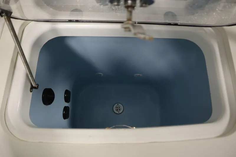 Slide: The Image of Livewell compartment of a 2017 Mako 284 CC boat, featuring a blue interior. - 47