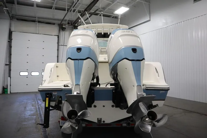 Slide: The Image of 2017 Mako 284 CC boat with dual outboard engines in a garage setting. - 5