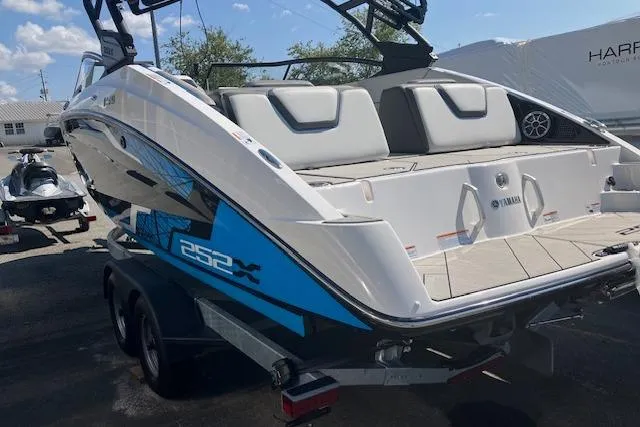 Slide: The Image of 2021 Yamaha Boats 252XE on trailer, featuring sleek design and spacious seating. - 12