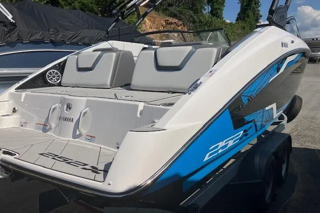 Slide: The Image of 2021 Yamaha Boats 252XE, sleek design, blue accents, spacious seating, rear view. - 13