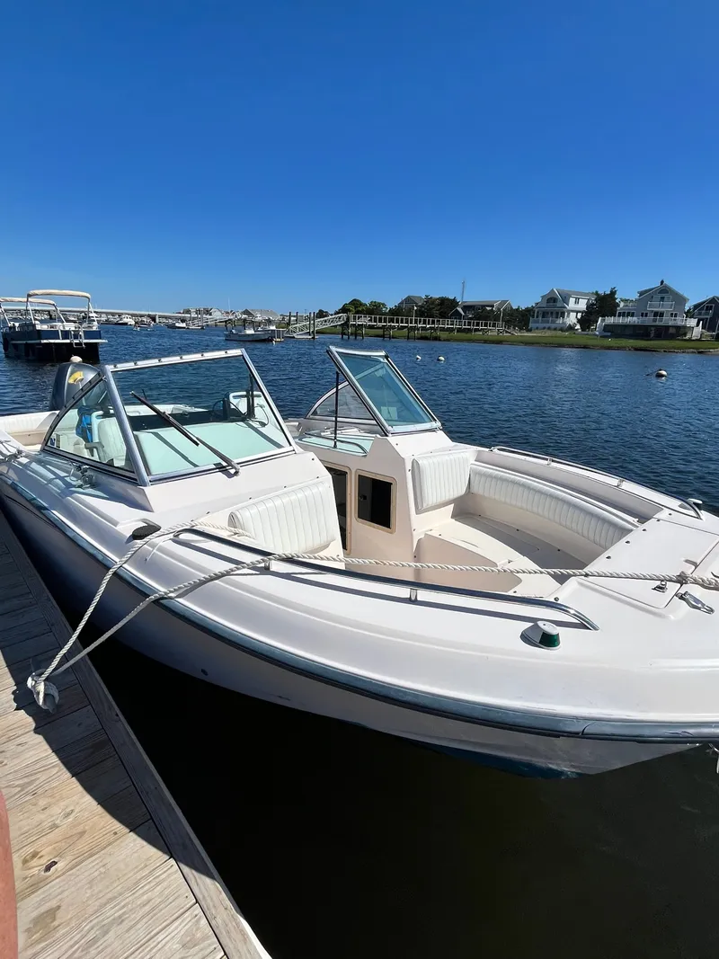 Slide: The Image of 1998 Grady-White 22 Tournament boat docked by a scenic waterfront. - 2