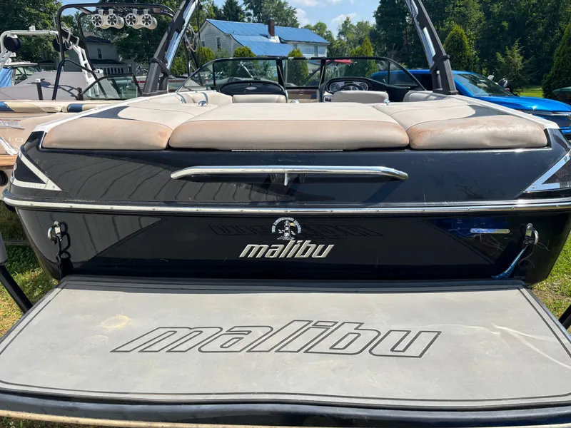 Slide: The Image of 2011 Malibu 21 vRide boat, rear view, showcasing sleek design and branding. - 12