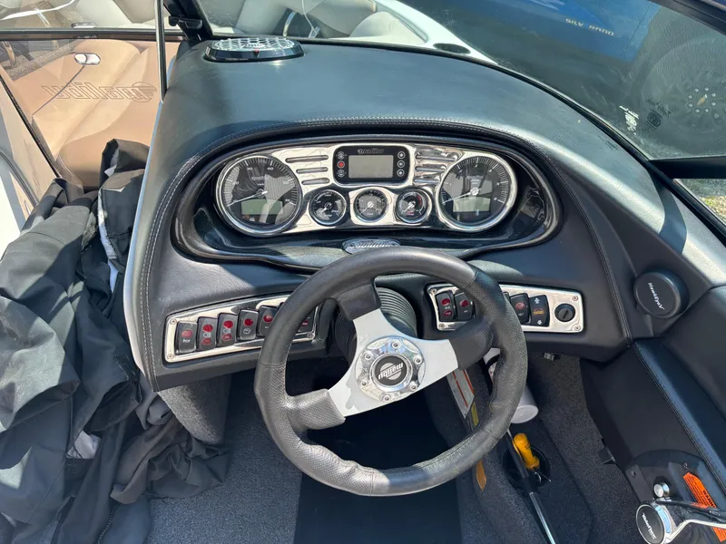 Slide: The Image of 2011 Malibu 21 vRide boat dashboard with steering wheel and control panel. - 7