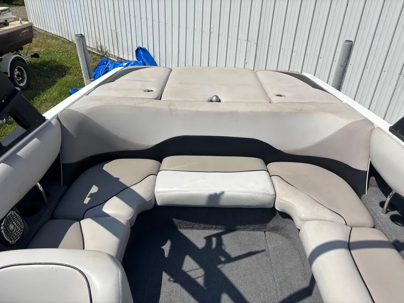 Slide: The Image of 2011 Malibu 21 vRide boat interior with gray seating and carpeted floor. - 8