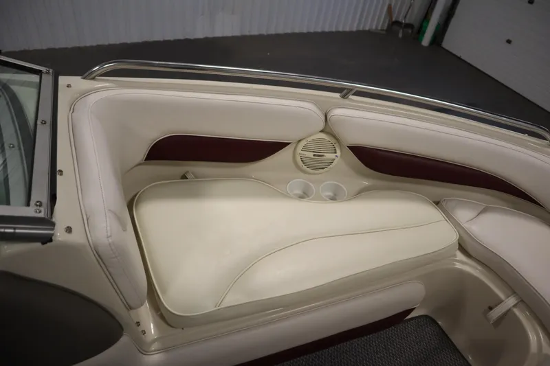 Slide: The Image of 2003 Crownline 202 BR boat interior with beige seating and cup holders. - 16
