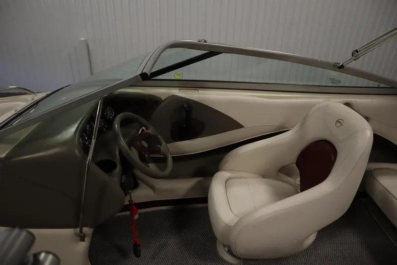 Slide: The Image of 2003 Crownline 202 BR boat interior with steering wheel and white seating. - 20