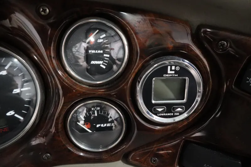 Slide: The Image of Dashboard of a 2003 Crownline 202 BR boat with trim, fuel, and depth gauges. - 25