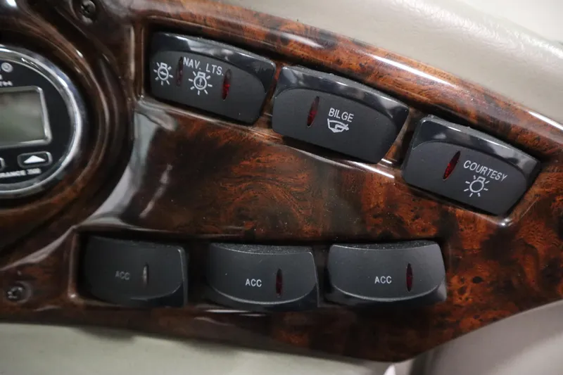 Slide: The Image of Dashboard controls of a 2003 Crownline 202 BR boat, featuring navigation and bilge switches. - 26