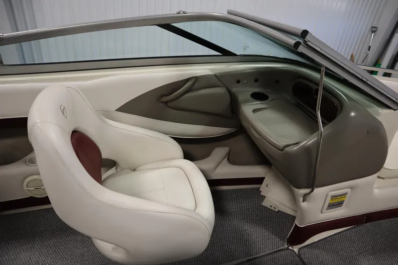 Slide: The Image of 2003 Crownline 202 BR boat interior with white and maroon seating, dashboard, and windshield. - 35