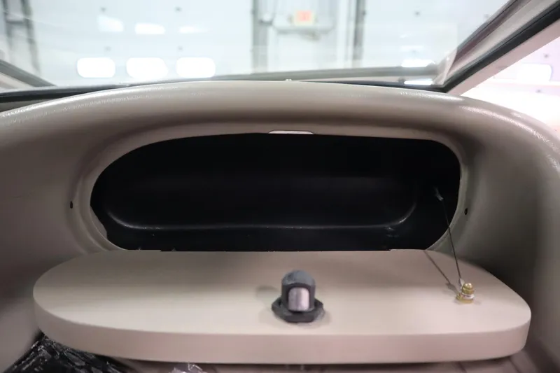 Slide: The Image of 2003 Crownline 202 BR boat dashboard compartment with open storage space. - 37