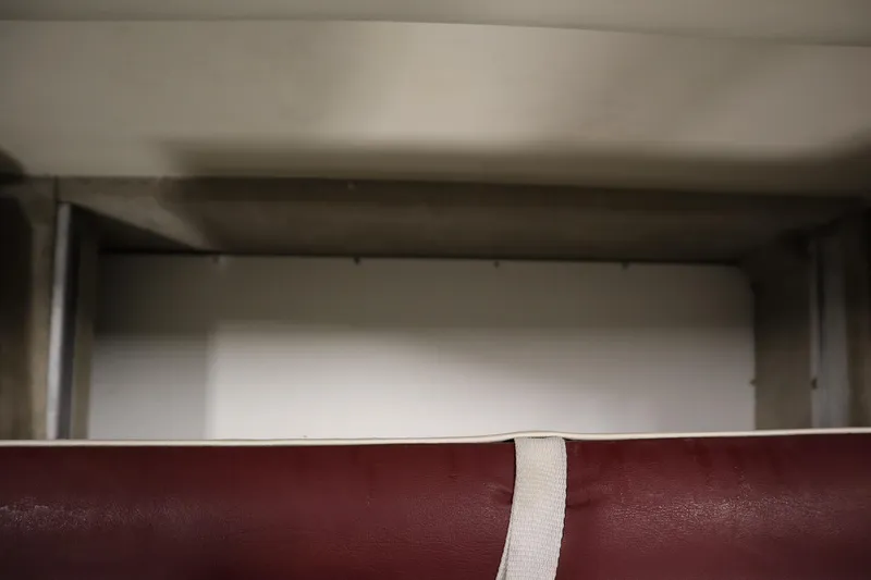 Slide: The Image of 2003 Crownline 202 BR boat interior storage compartment with maroon upholstery. - 44